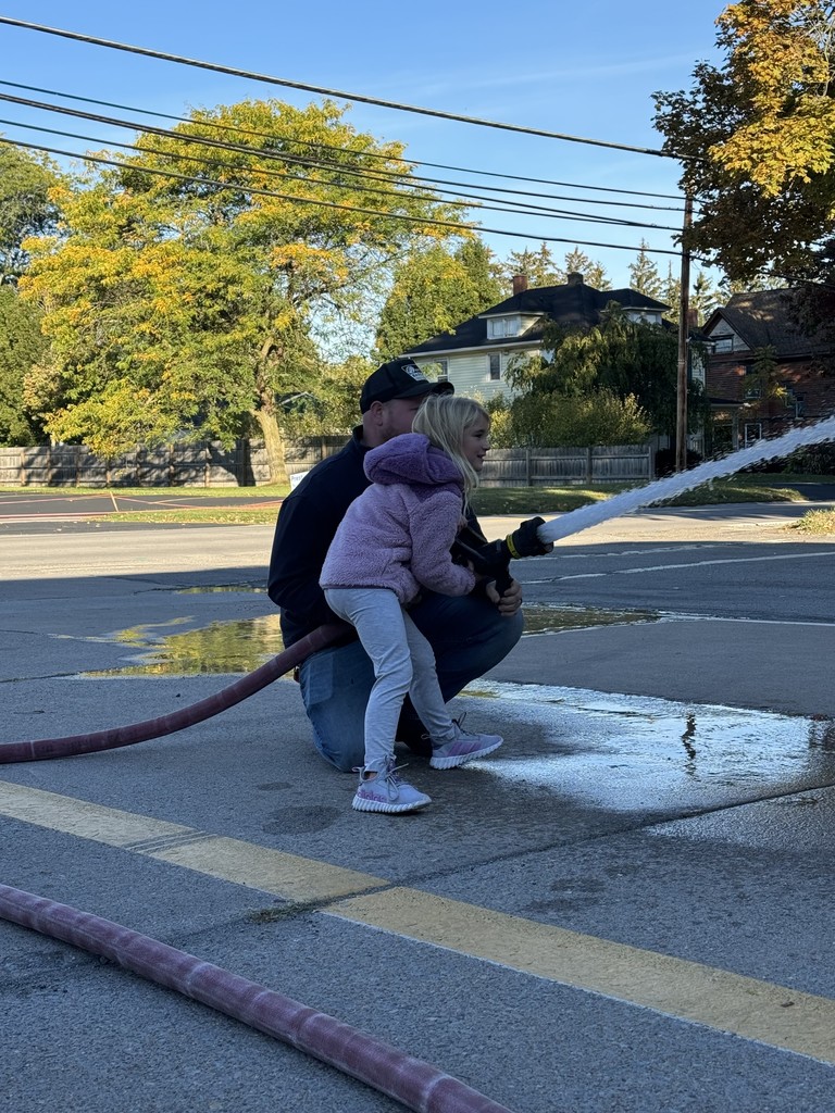 student using firehose with firefighter