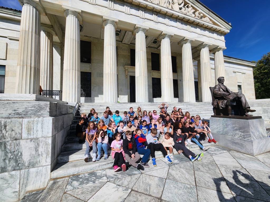 students sitting outside museum on steps