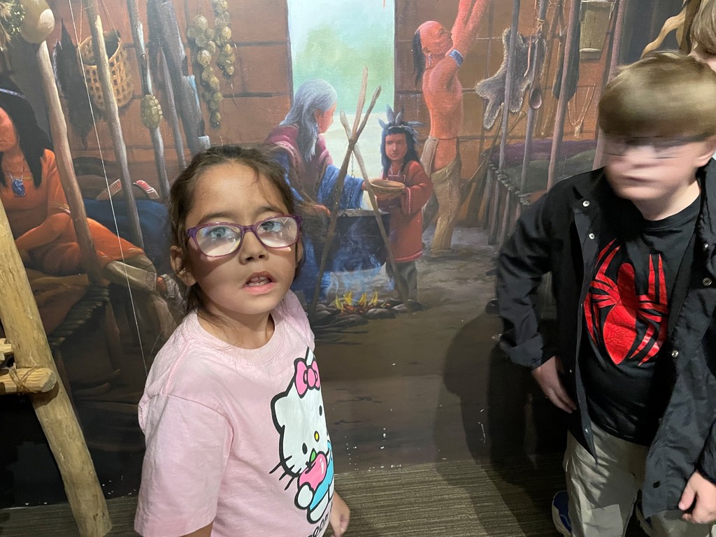 two students standing near mural