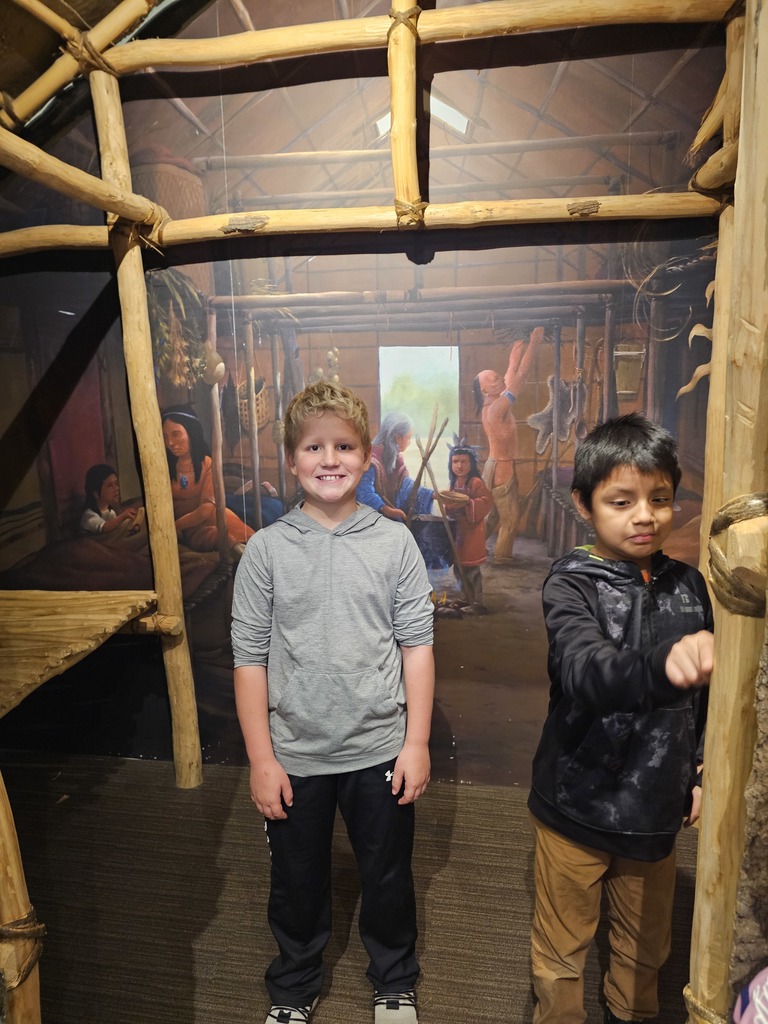 two students in a long house in the museum