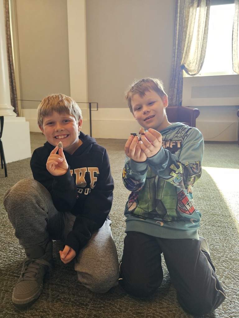 two students holding items from museum