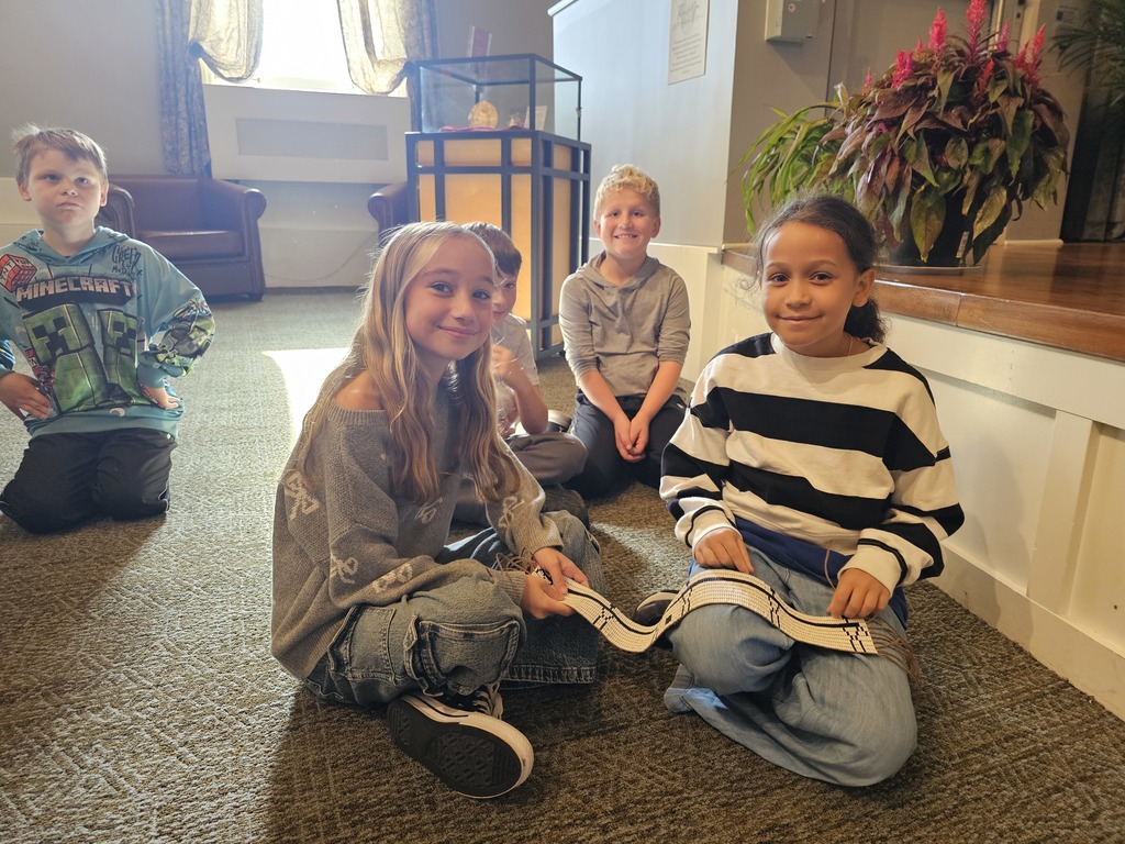 two students holding a cloth item in museum