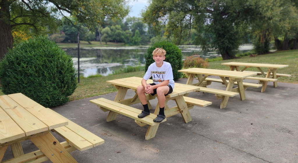 boy sitting on top of picnic table