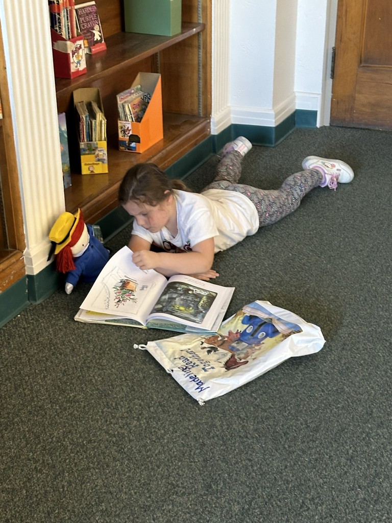 girl reading a book lying on the floor