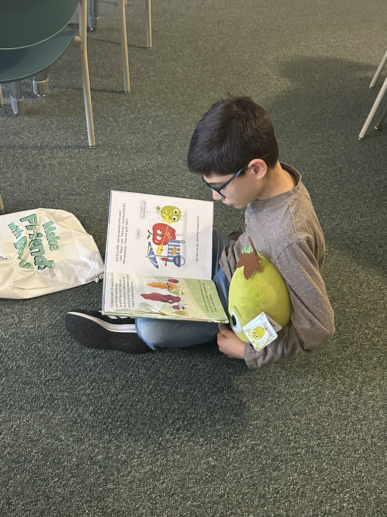 boy reading a book sitting on the floor