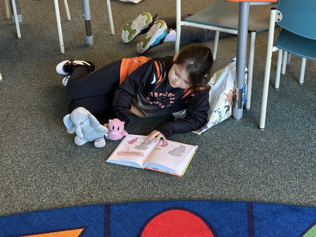 girl reading a book lying on the floor