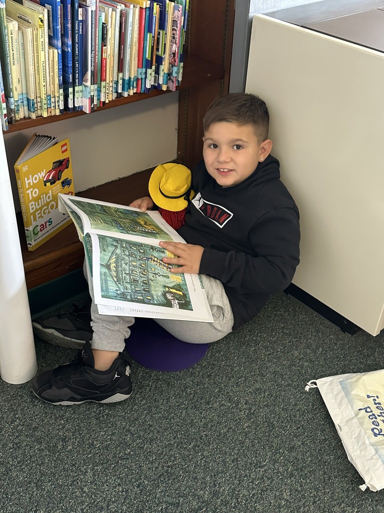 boy reading a book sitting on the floor