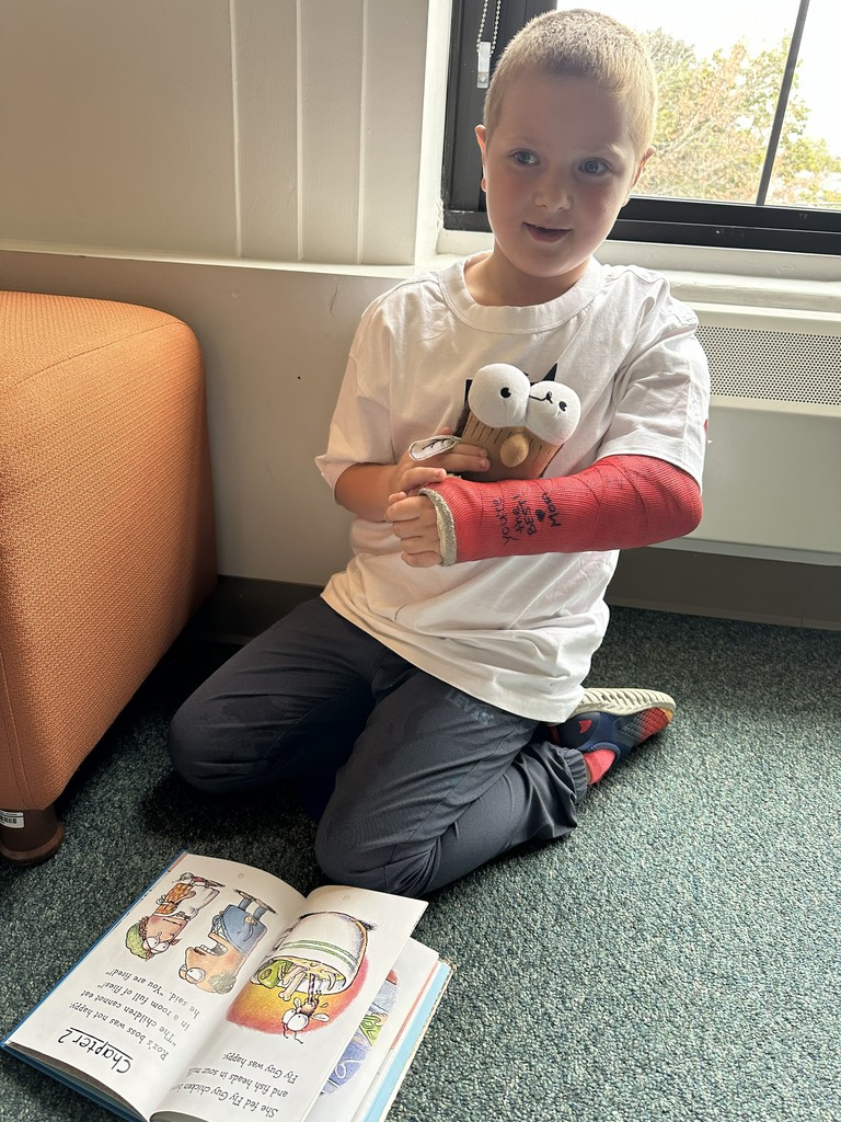 boy reading a book kneeling on the floor