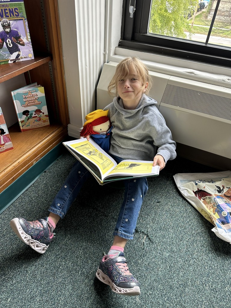 girl reading a book sitting on the floor