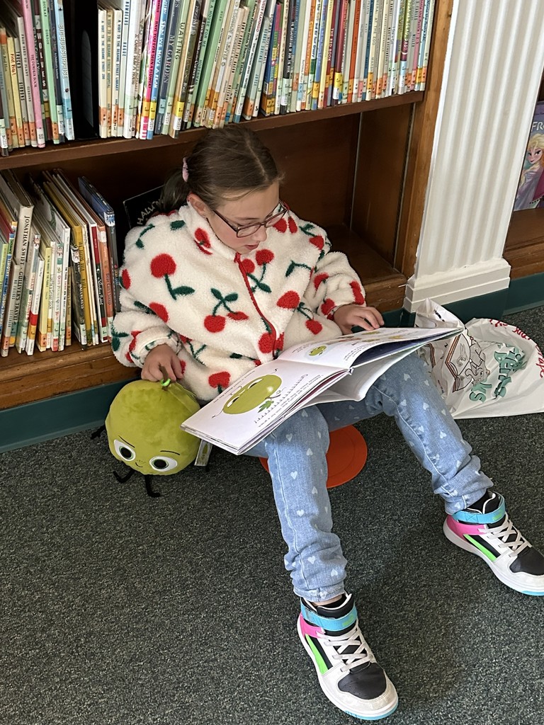girl reading a book sitting on the floor