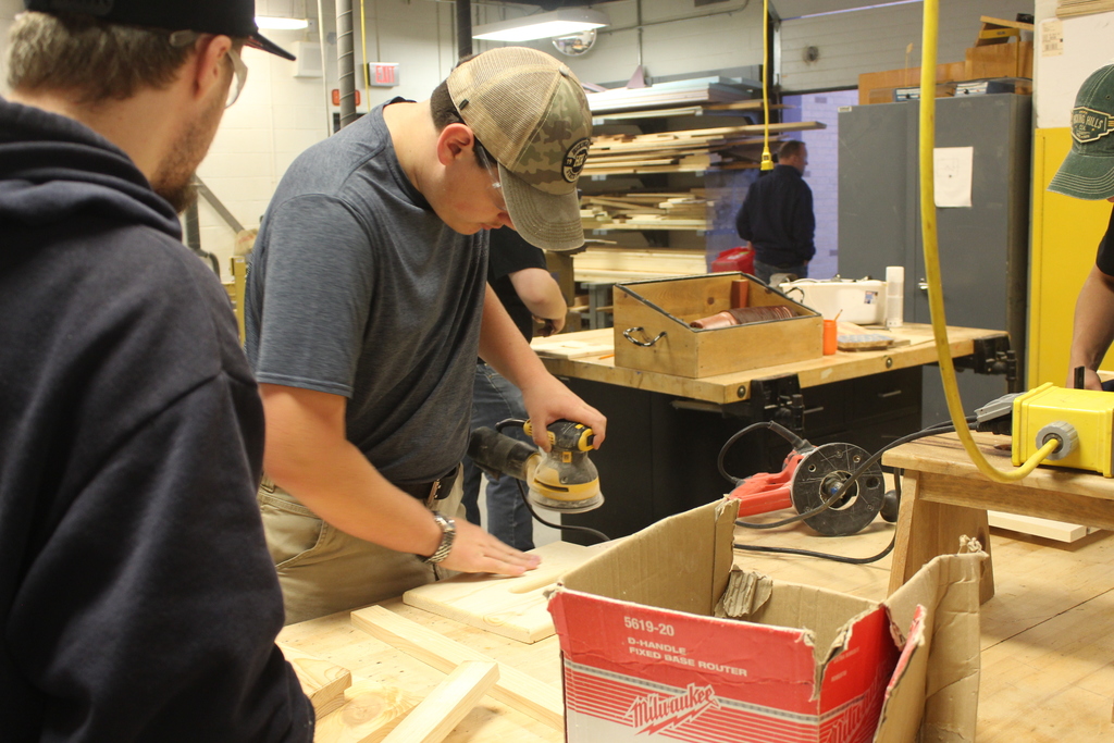 boy using sander on a piece of wood