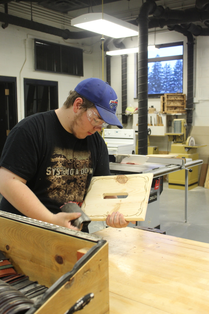 boy sanding wooden piece