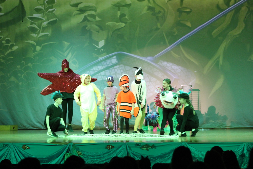 students acting on stage in costumes