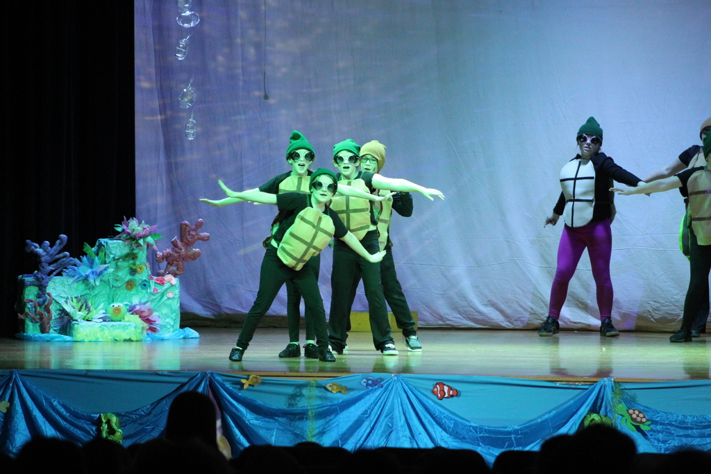 students dancing on stage in costumes