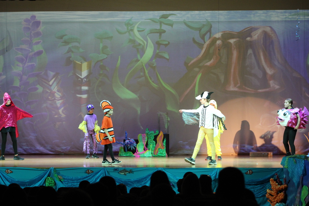 students acting on stage in costumes