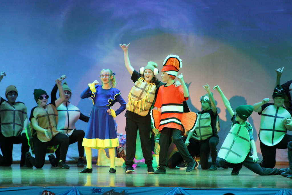 students singing on stage in costumes