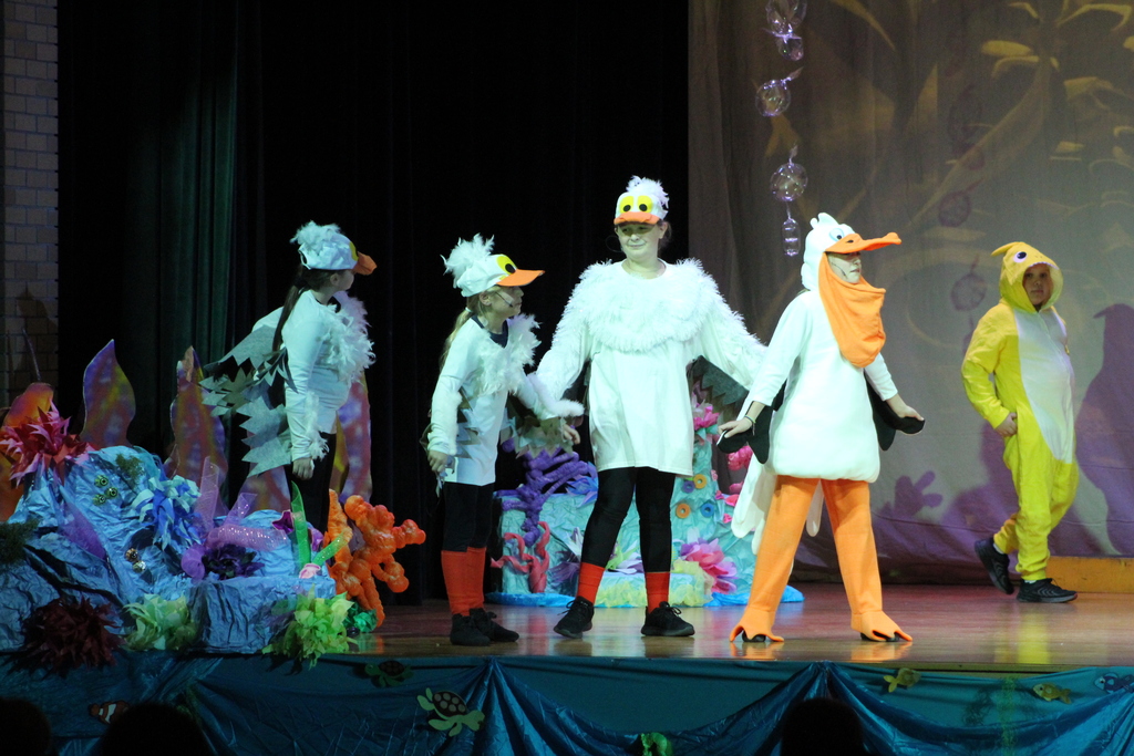 students acting on stage in costumes