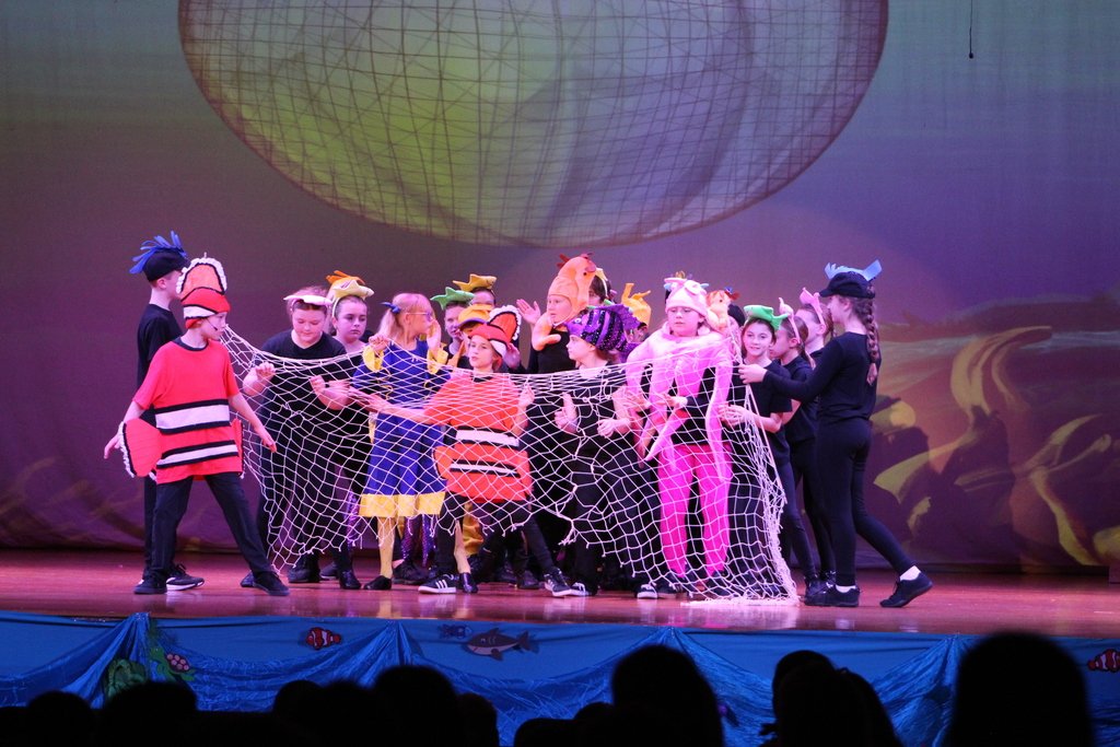 students acting on stage in costumes