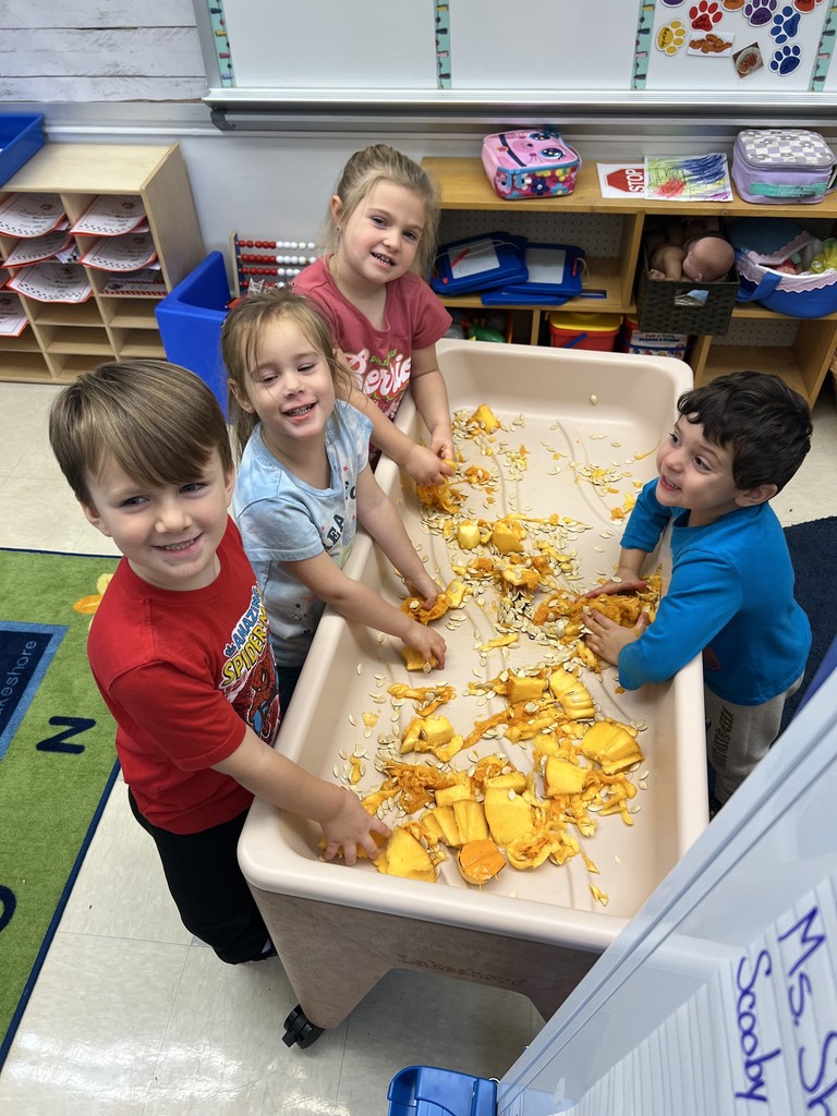 students playing with pumpkin guts in classroom