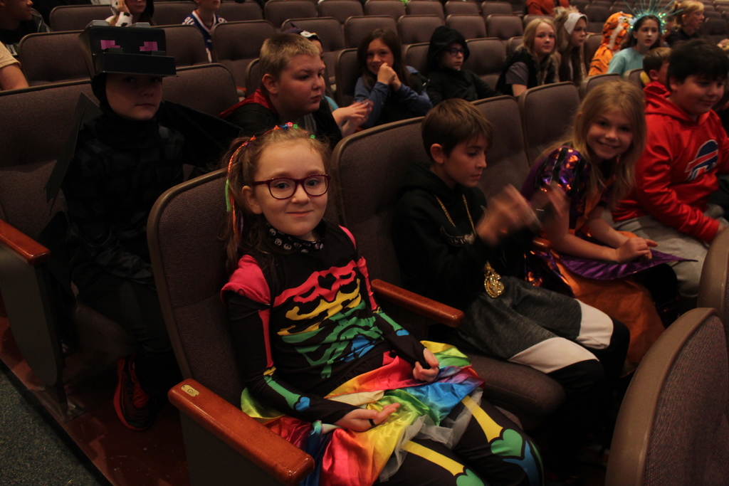 students sitting in the auditorium in their costumes