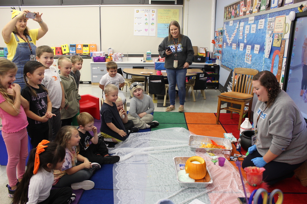 students watching pumpkin experiment that teacher is doing