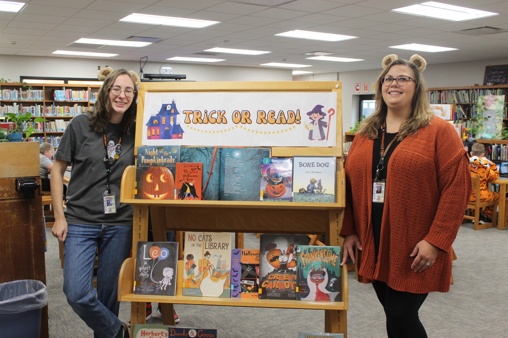 library staff member standing next to Halloween book display