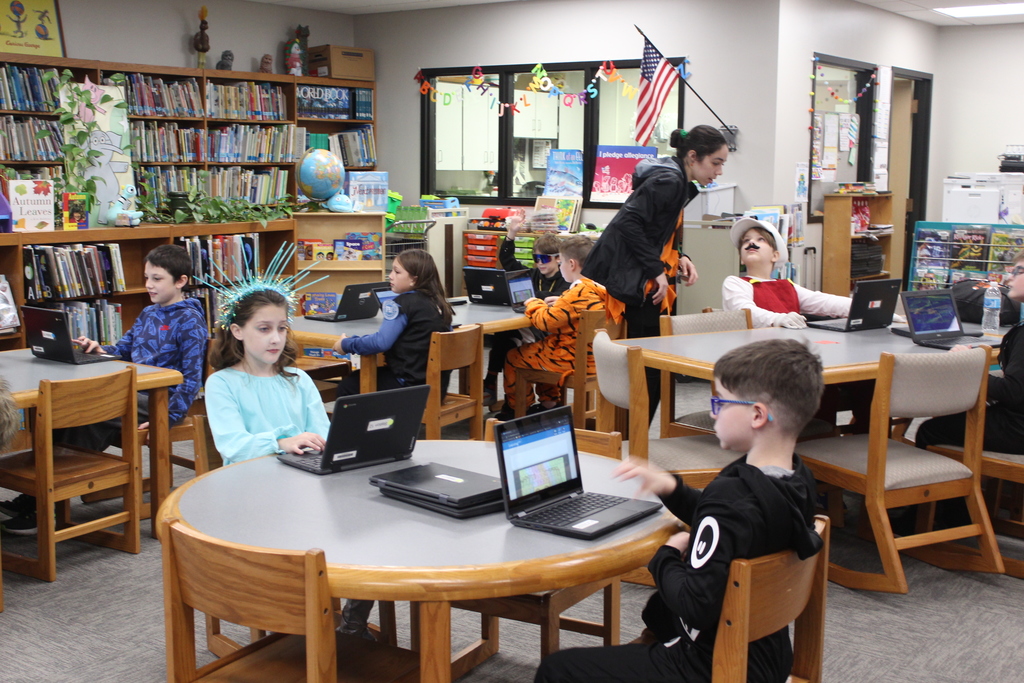 students working on devices in the library