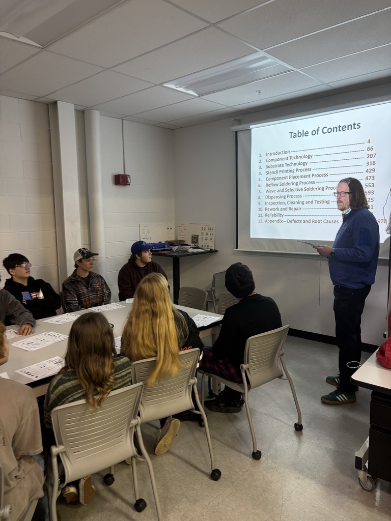 students listening to an adult in a classroom
