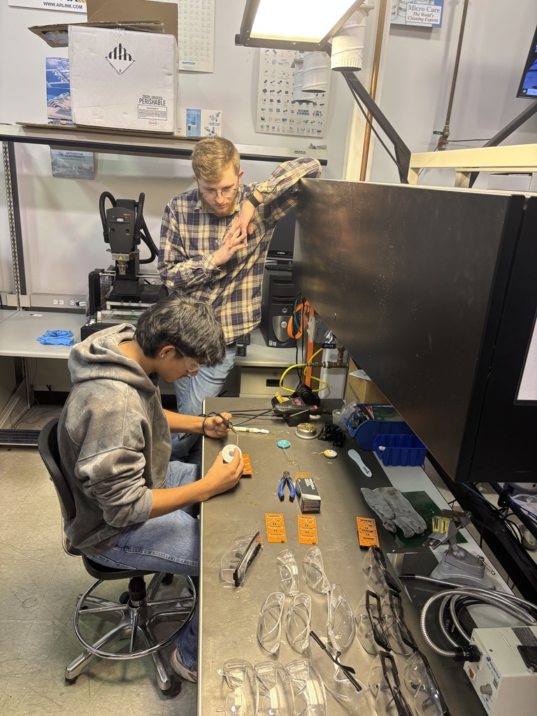 two students working on something on a workbench