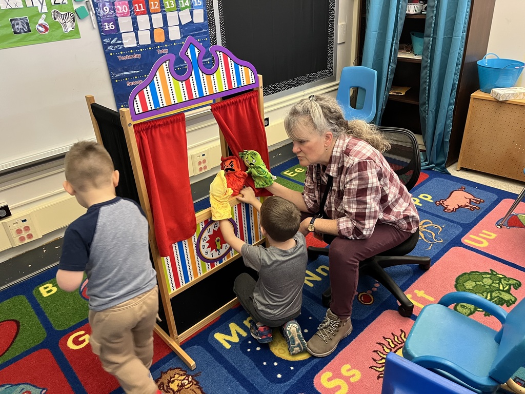 student playing puppets with teacher