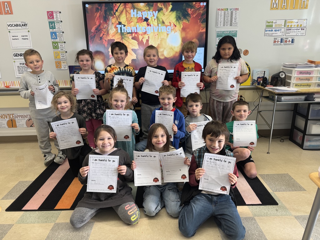 students holding up worksheets they completed