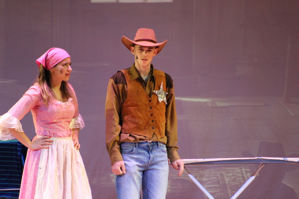 two students standing on stage