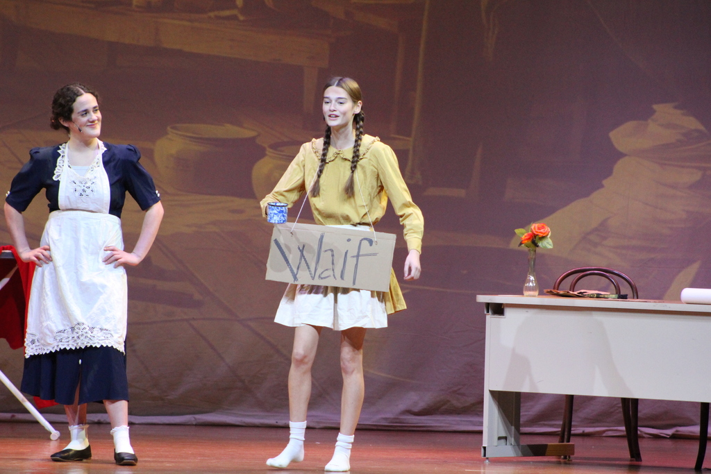 two students standing on stage