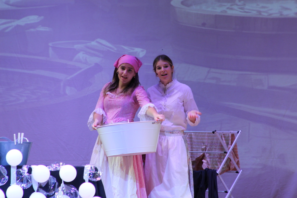 two students standing on stage together