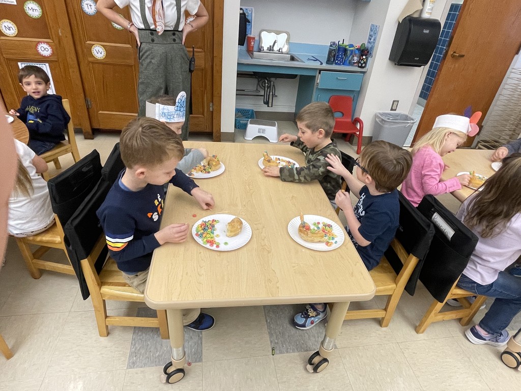 students sitting at a table working with food