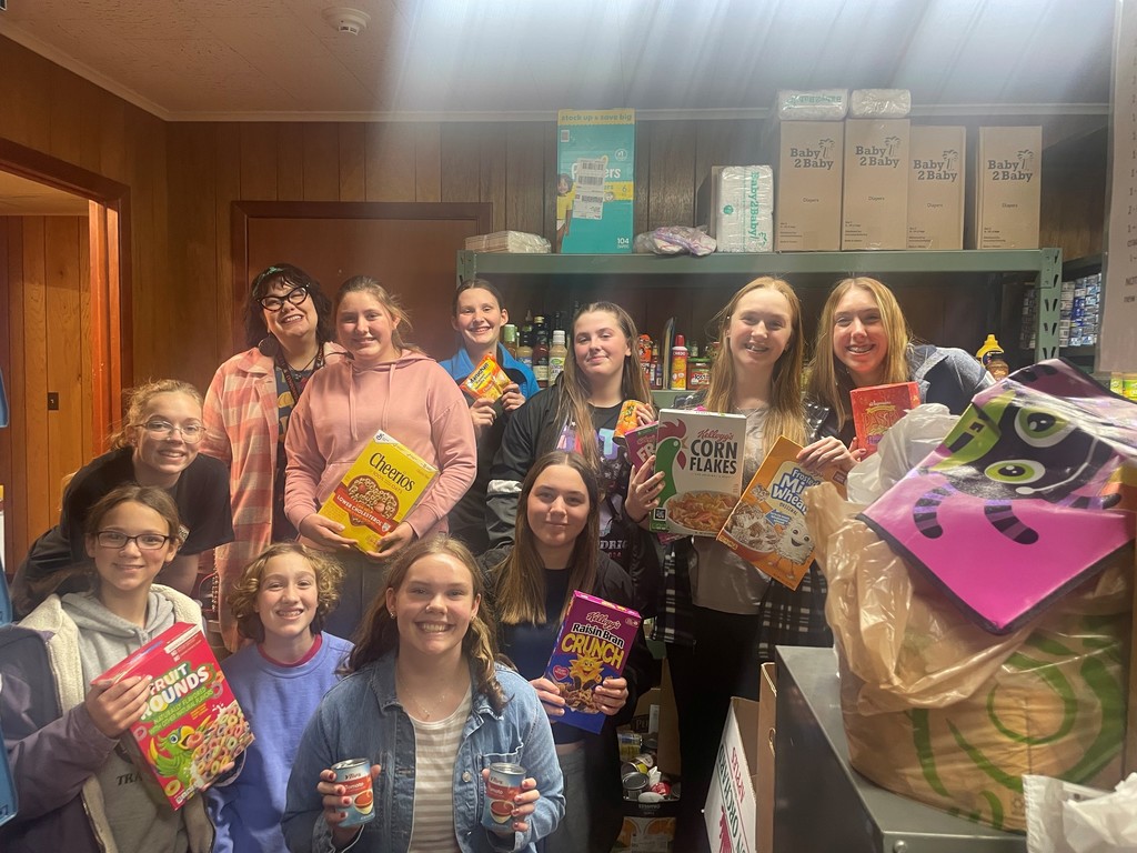 students and staff holding donated food items