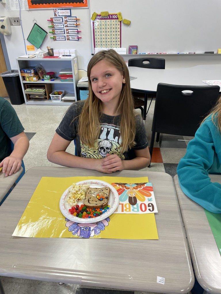 student sitting at table with a plate of food