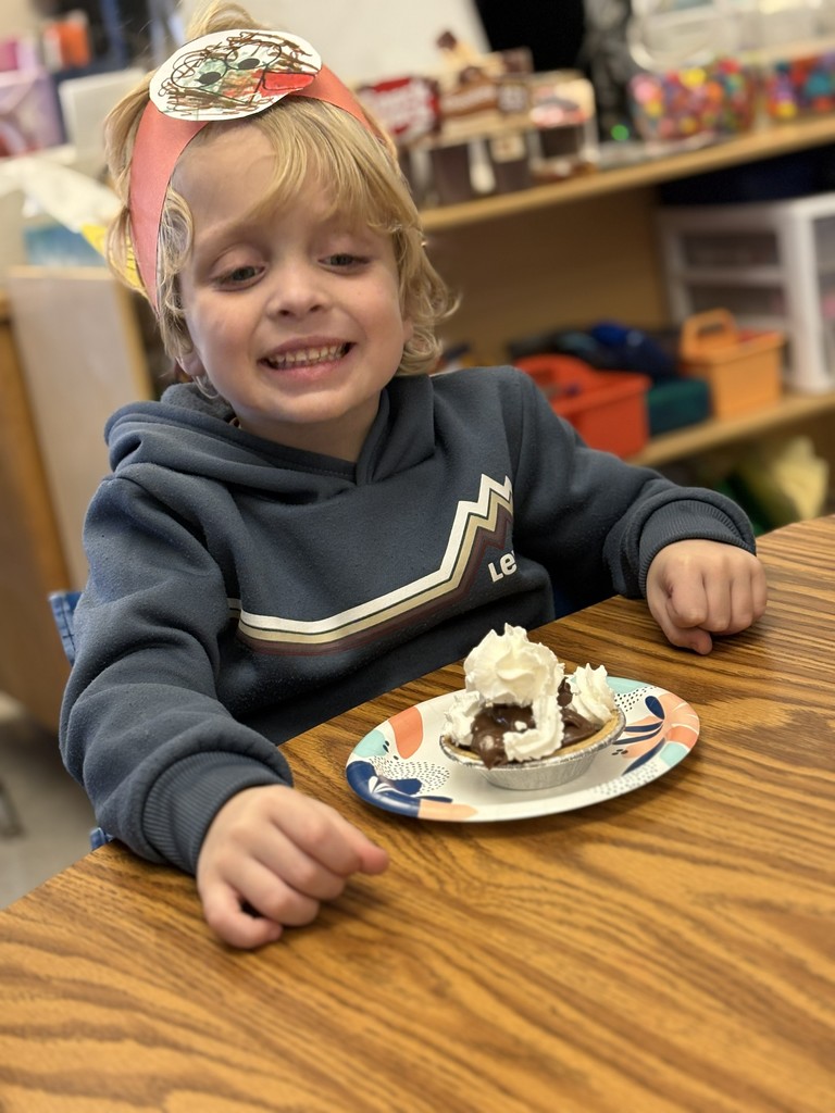 boy sitting with pie at table