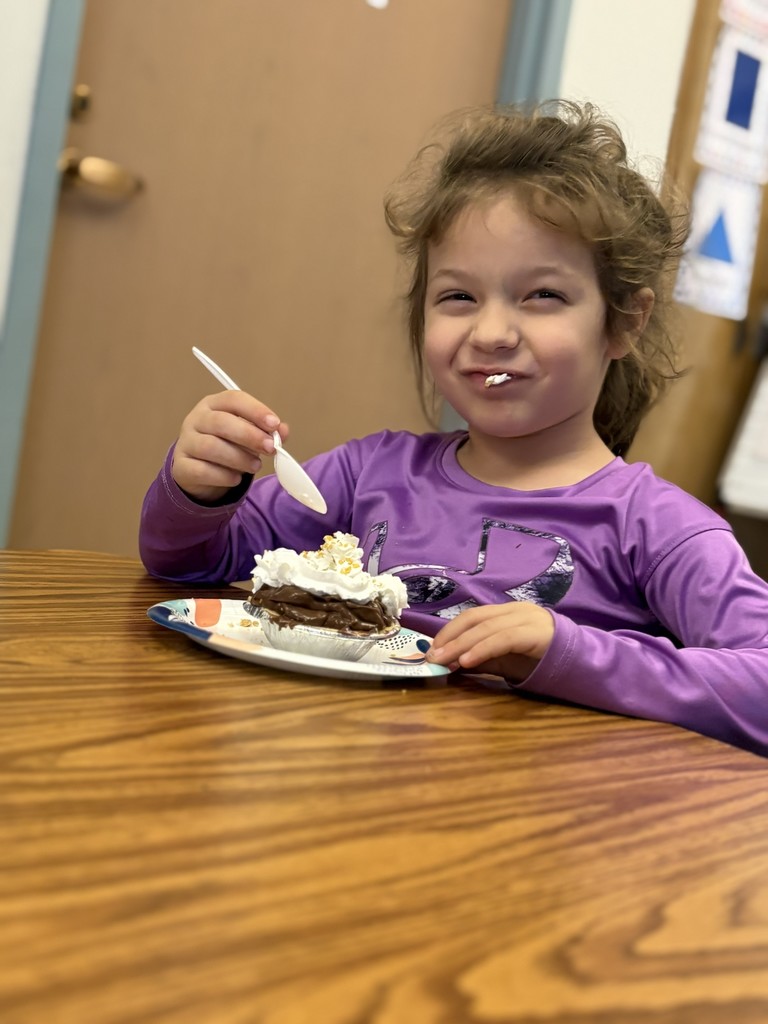 girl eating pie at table