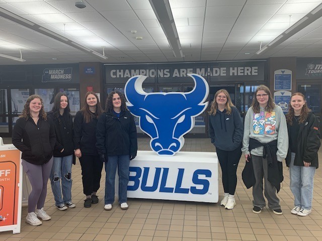 students standing near a bulls sports logo