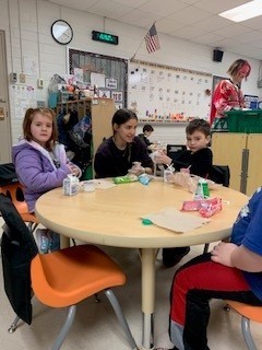 students seated at table doing an activity