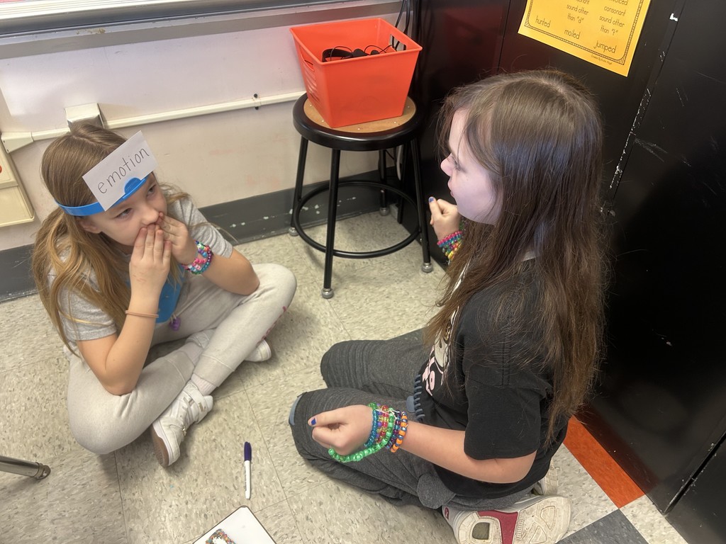 two girls sitting on the floor playing a game