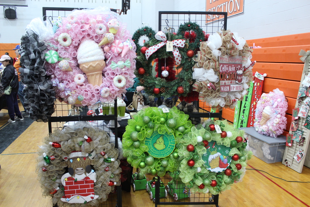 a variety of wreaths hanging from a booth wall
