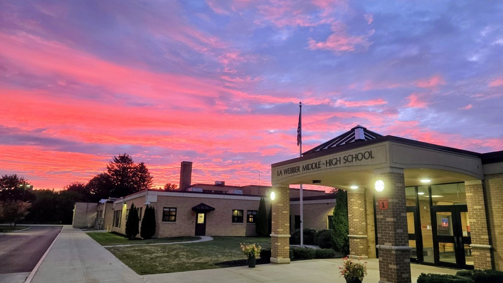 building with lights on and a vibrant pink and blue cloudy sky behind it