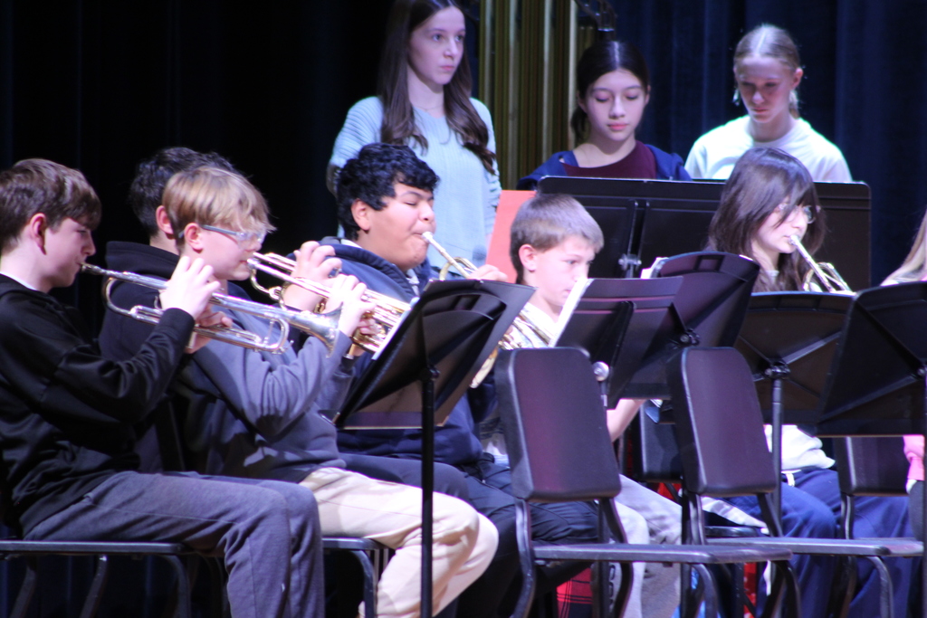 students playing instruments in band on stage