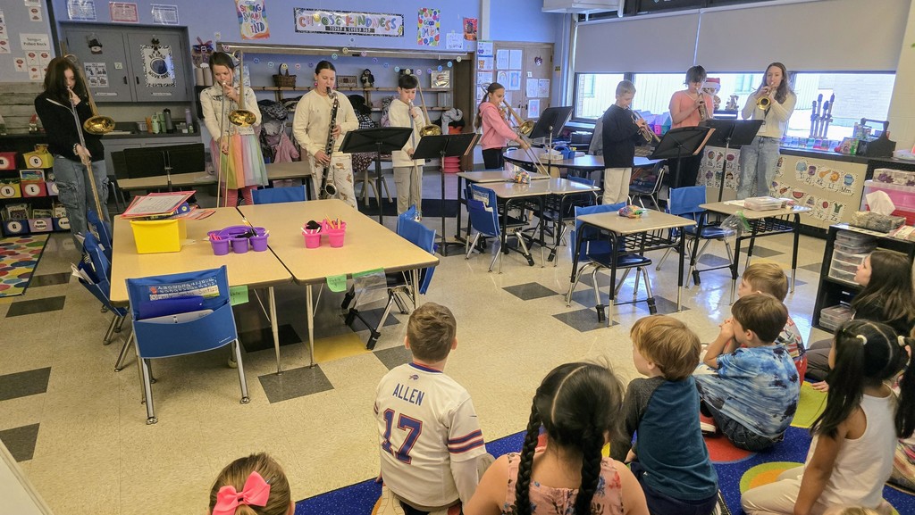 students playing music in a classroom for younger students