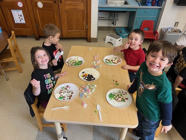 students sitting at tables working on gingerbread people