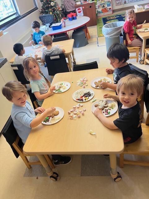 students sitting at tables working on gingerbread people