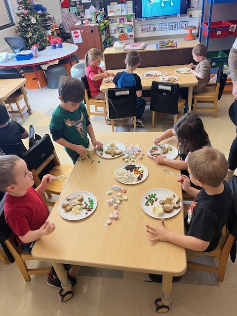 students sitting at tables working on gingerbread people