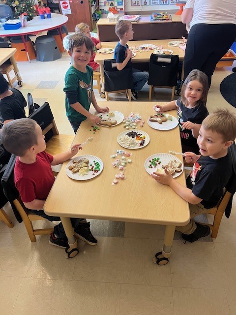 students sitting at tables working on gingerbread people